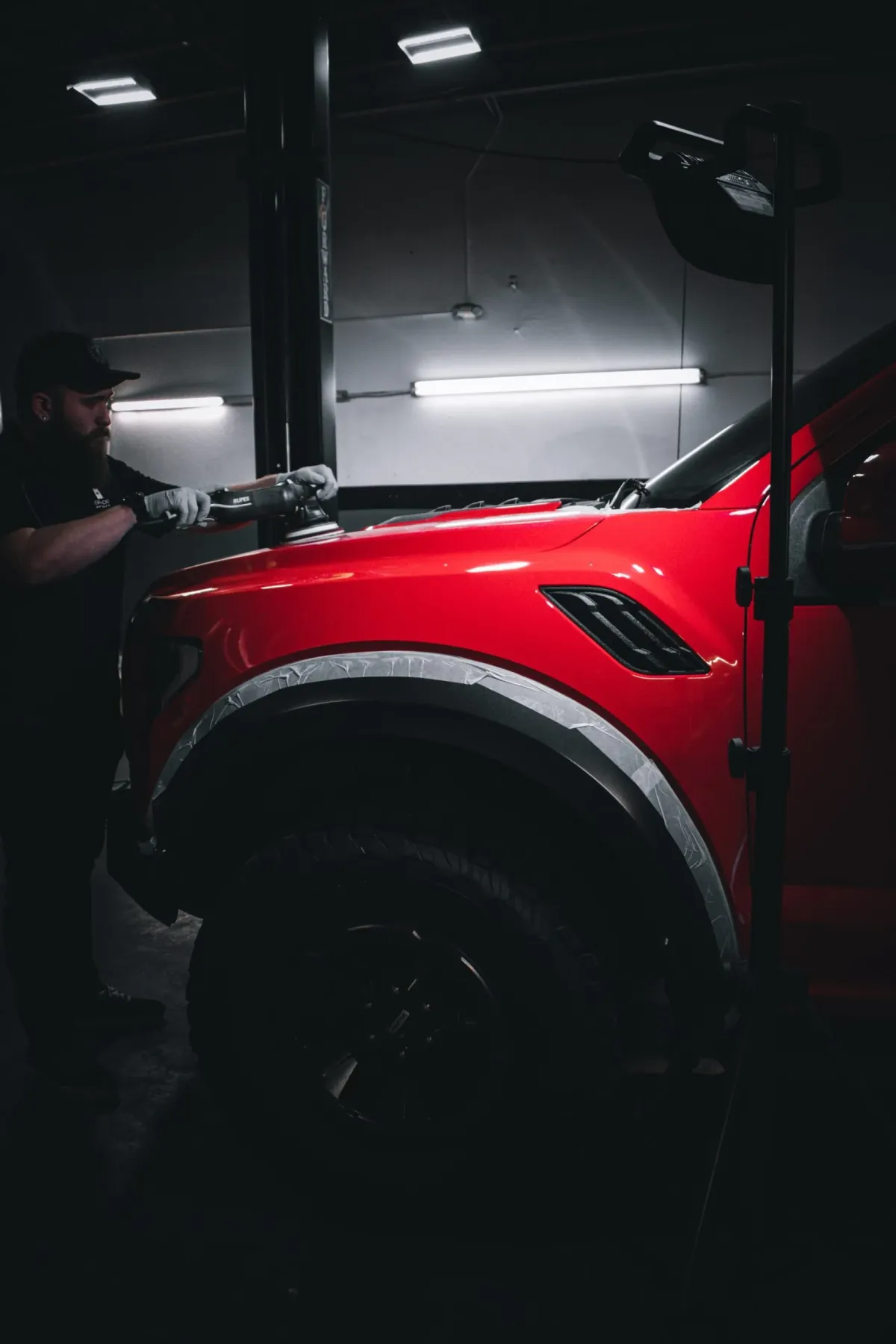 Technician working on a vehicle inside the detailing shop